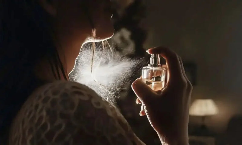 Woman spraying perfume on neck, elegant fragrance mist in low light setting