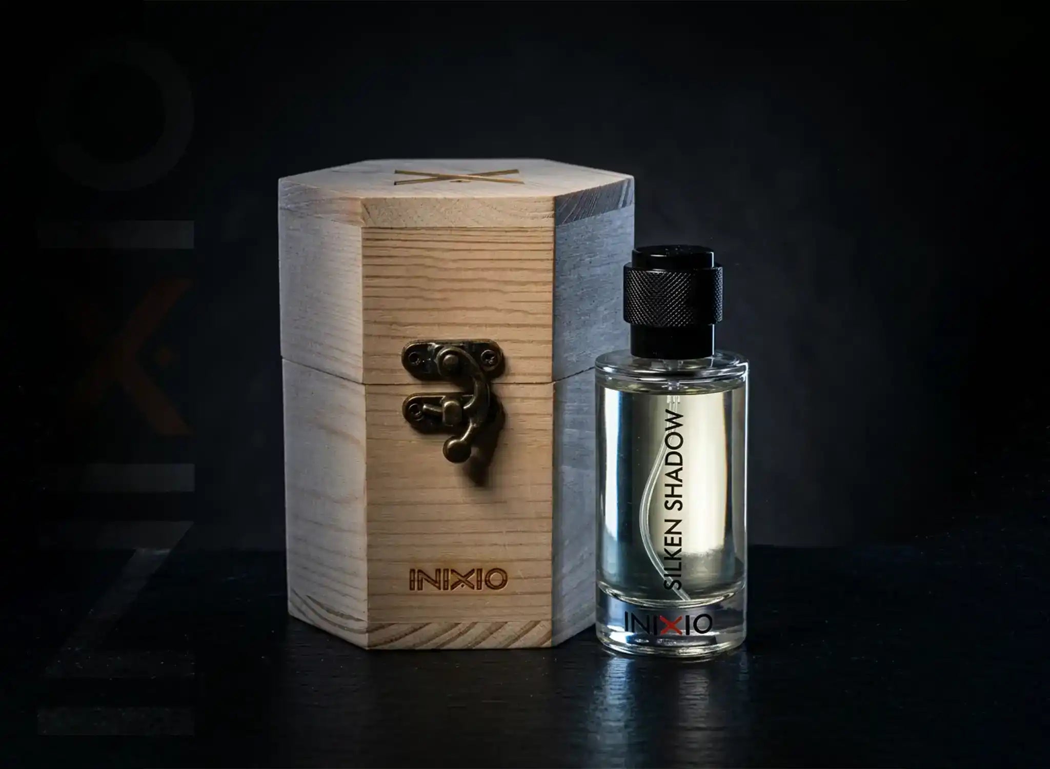 Inixio Perfume bottle with wooden box labeled 'INXIO' on a dark background