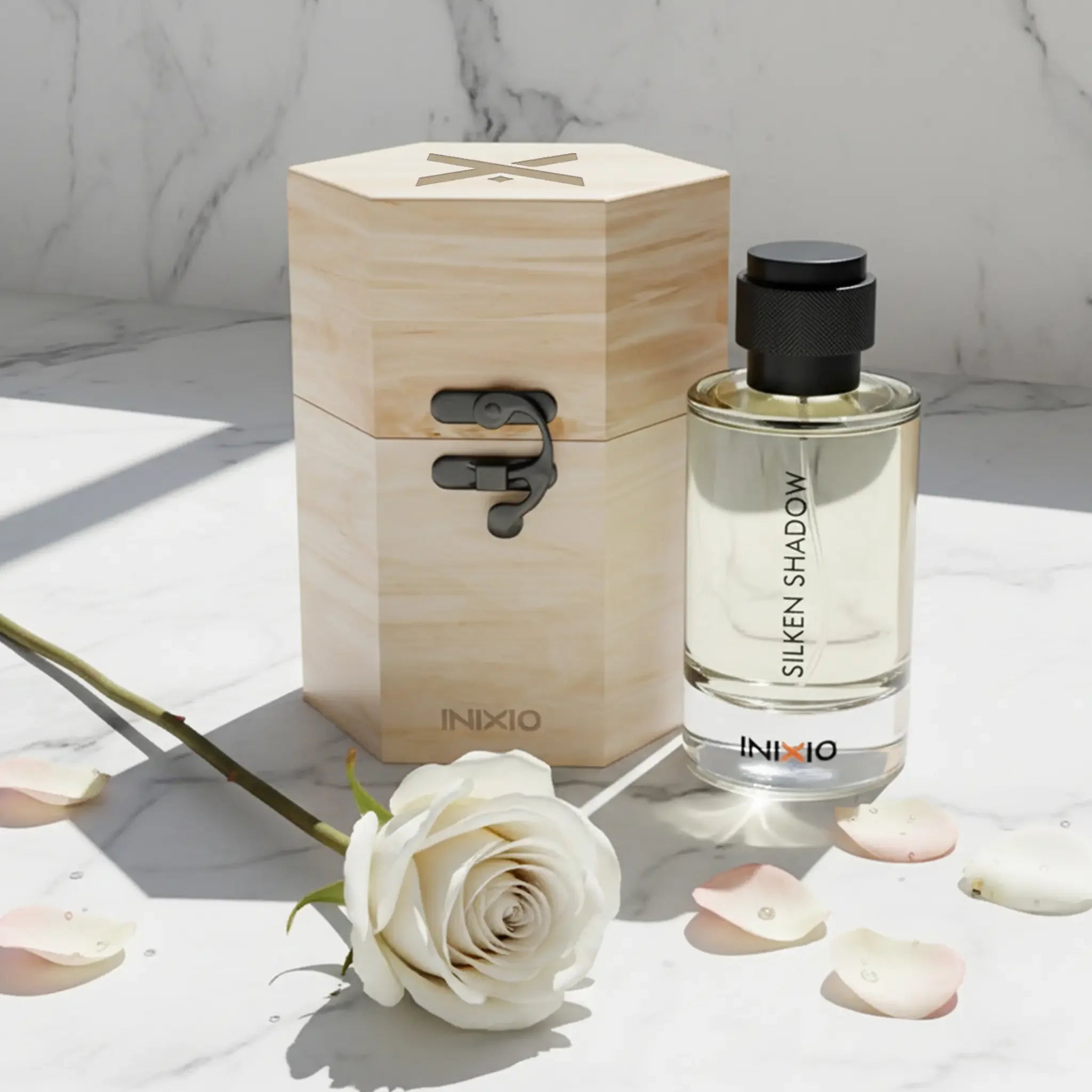 Silken Shadow unisex perfume bottle with wooden box, white rose, and rose petals on marble