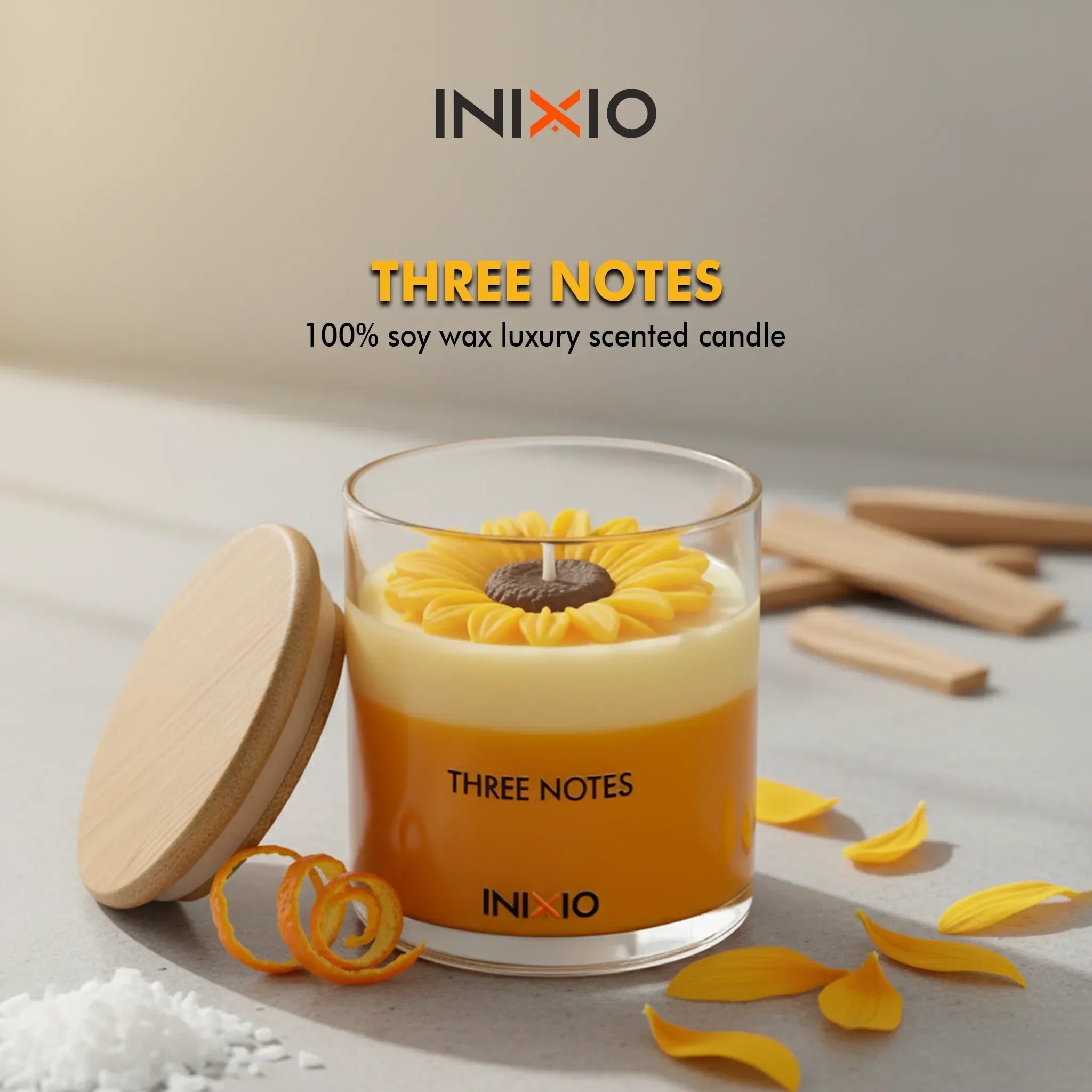 Yellow soy wax scented candle in glass jar with flower design, wooden lid, and petals on table.
