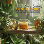 Scented candle with sunflower design in glass jar on wooden shelf surrounded by green plants